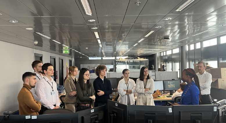 Image of Image of CARE Luxembourg people standing around listening to speaker in office